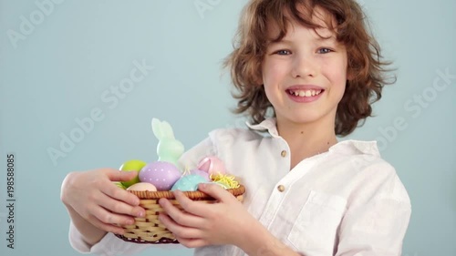 Curly boy with an Easter basket. First a serious look on his face, then he laughs. Waiting for a holiday photo
