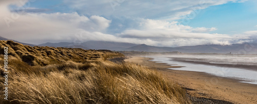 Scenic panorama view of grass covered sand dunes on Banna beach in county Kerry, Ireland
