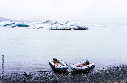 two inflatable ribs by the shore with icebergs