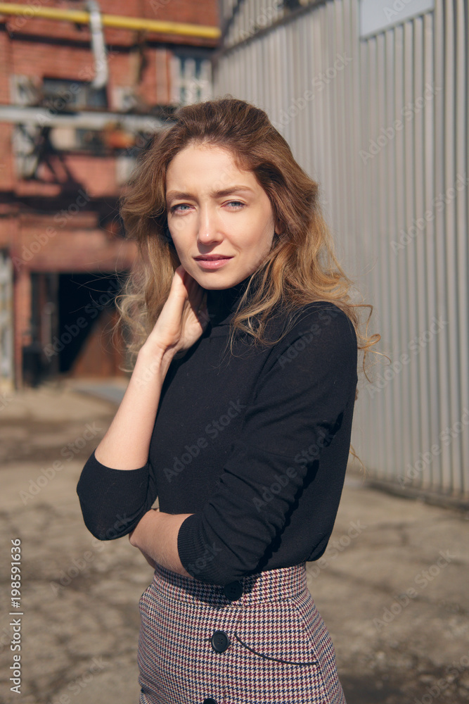 Fototapeta premium Street fashion, urban style. Girl in longsleeve and skirt on backjard