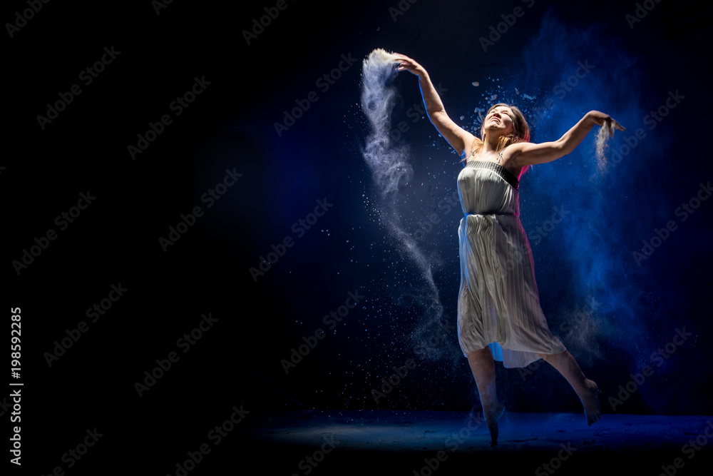 Old fat ballerina tries to dance in the studio during photoshoot with flour on a black background