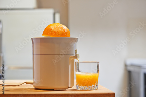 Electric juicer and juicy glass in a modern kitchen photo
