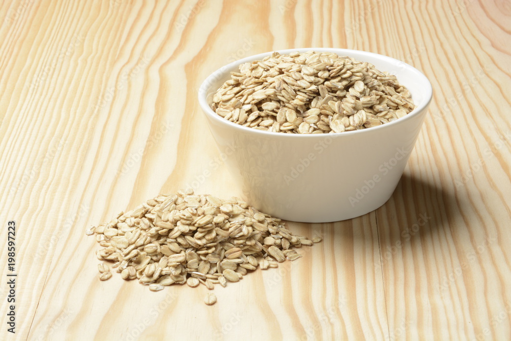 Avena cruda o copos sobre fondo de madera Avena cruda o copos sobre fondo de madera