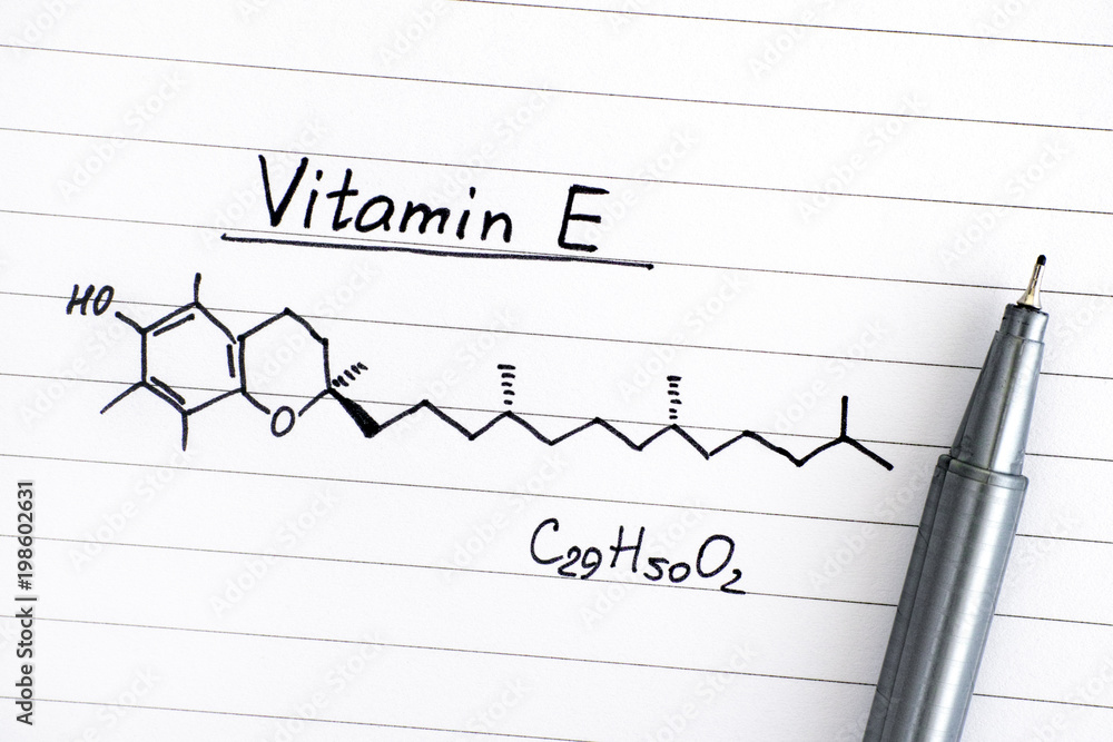 Chemical formula of Vitamin E on lined paper with pen. Stock Photo