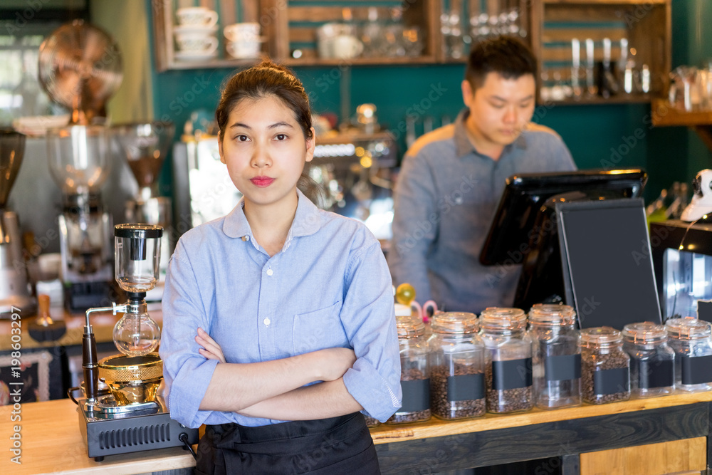 Serious confident young Asian owner working in coffee house. Strict