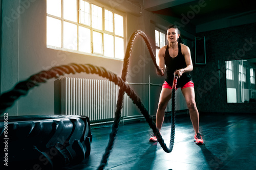 Doing intense hard intensive training with rope at gym