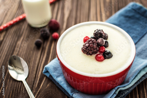Photos Semolina porridge with raspberries on rustic wooden background