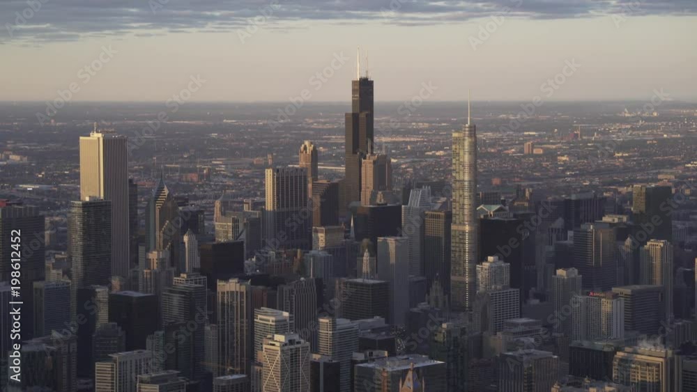 Chicago early morning aerial view of the Chicago loop with Willis Tower center focused. Soft warm light reflecting off of surrounding buildings Chicago early morning aerial view of the Chicago loop with Willis Tower center focused. Soft warm light reflecting off of surrounding buildings