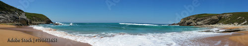 Beach with beautiful waves and blue sky, landscape. North Spain