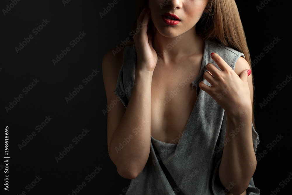 Sexy young woman in a torn shirt on black background. Sexy young woman in a torn shirt on black background.