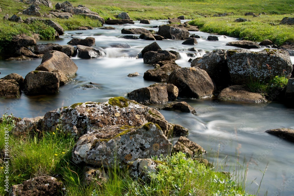 Island steiniges Flussbett in grüner Umgebung Island steiniges Flussbett in grüner Umgebung