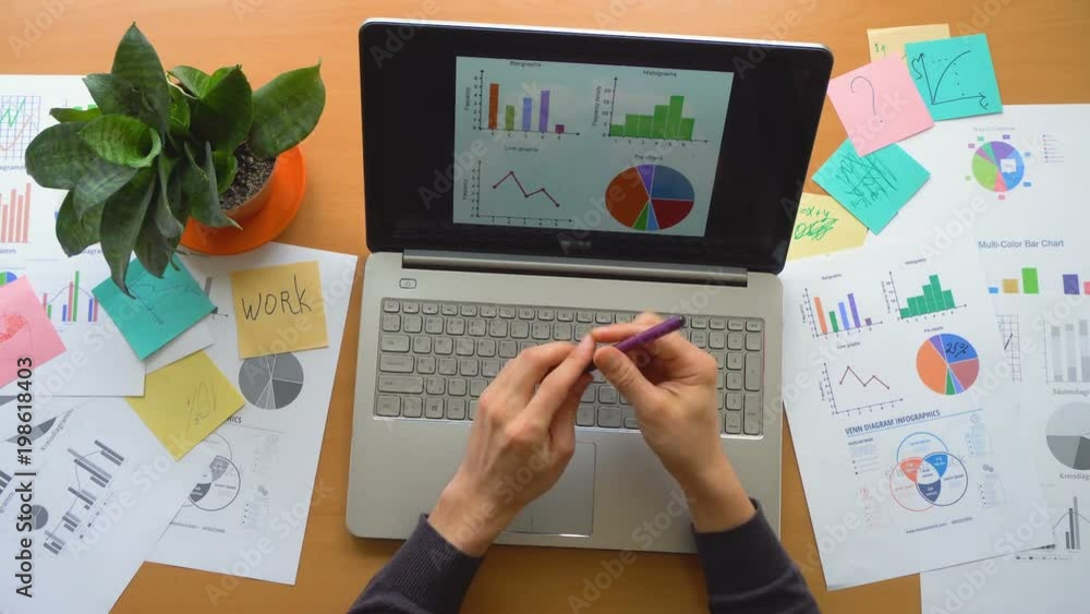 Man working at office with laptop surrounded by a lot of paperwork, top view Man working at office with laptop surrounded by a lot of paperwork, top view