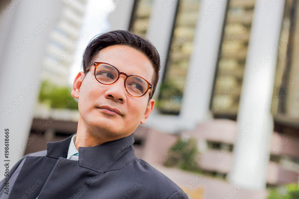 Asia young business man in front of the modern building in downtown .Concept of young business people Asia young business man in front of the modern building in downtown .Concept of young business people