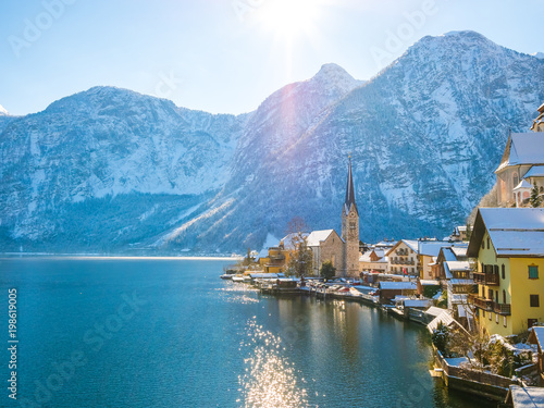 Classic postcard view of famous Hallstatt lakeside town in the Alps moutain ship on a beautiful cold sunny day with blue sky and clouds in winter, Salzkammergut region, Austria