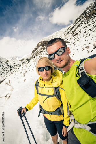 Couple hikers, partnership and teamwork in winter mountains