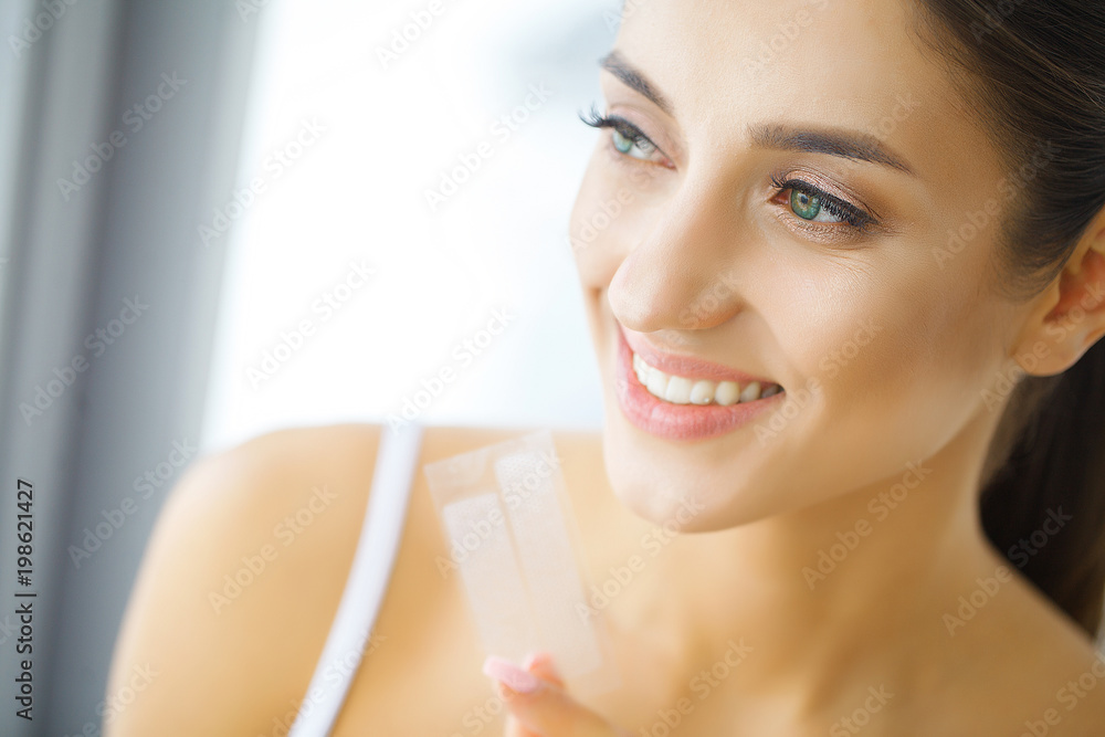Teeth Whitening. Beautiful Smiling Woman Holding Whitening Strip. High Resolution Image Teeth Whitening. Beautiful Smiling Woman Holding Whitening Strip. High Resolution Image