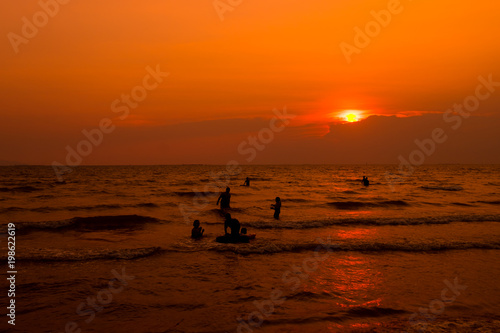 People are swimming in the sea, relaxing. At sunset © anurak