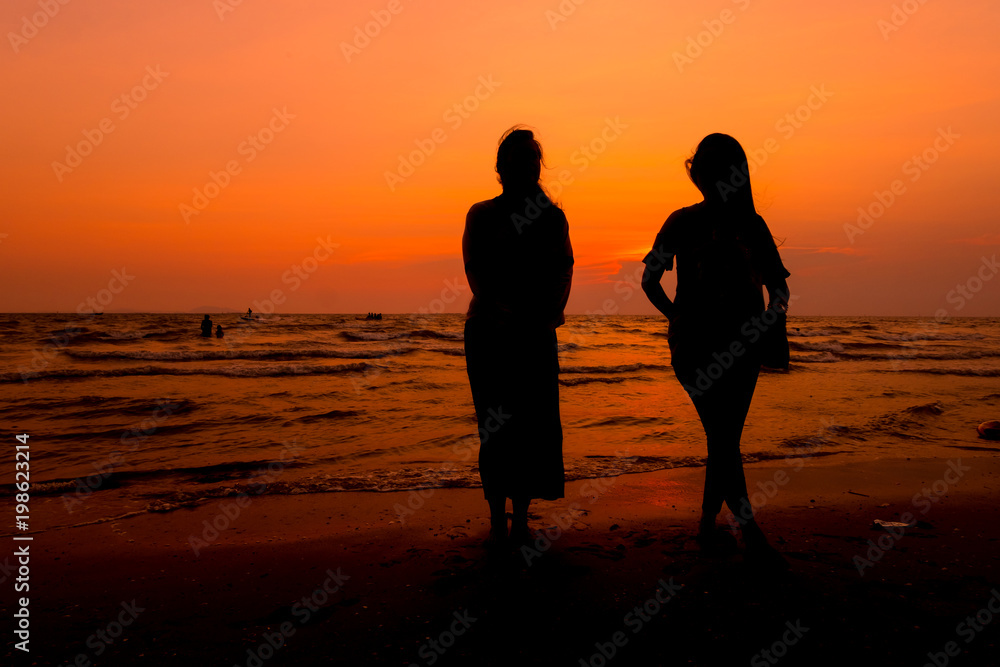 Woman is walking on the beach relaxing at sunset.