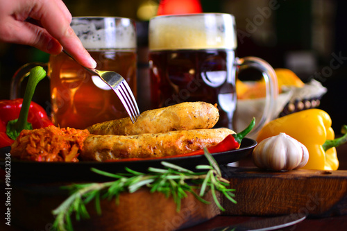 Photography Tasty sausages with a beer on a table of a restaurant pub