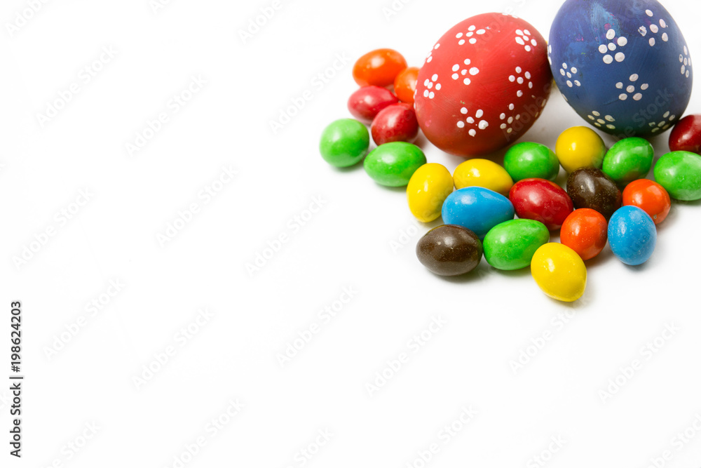 Obraz premium Painted Easter eggs with candy egg on white backgrou isolated