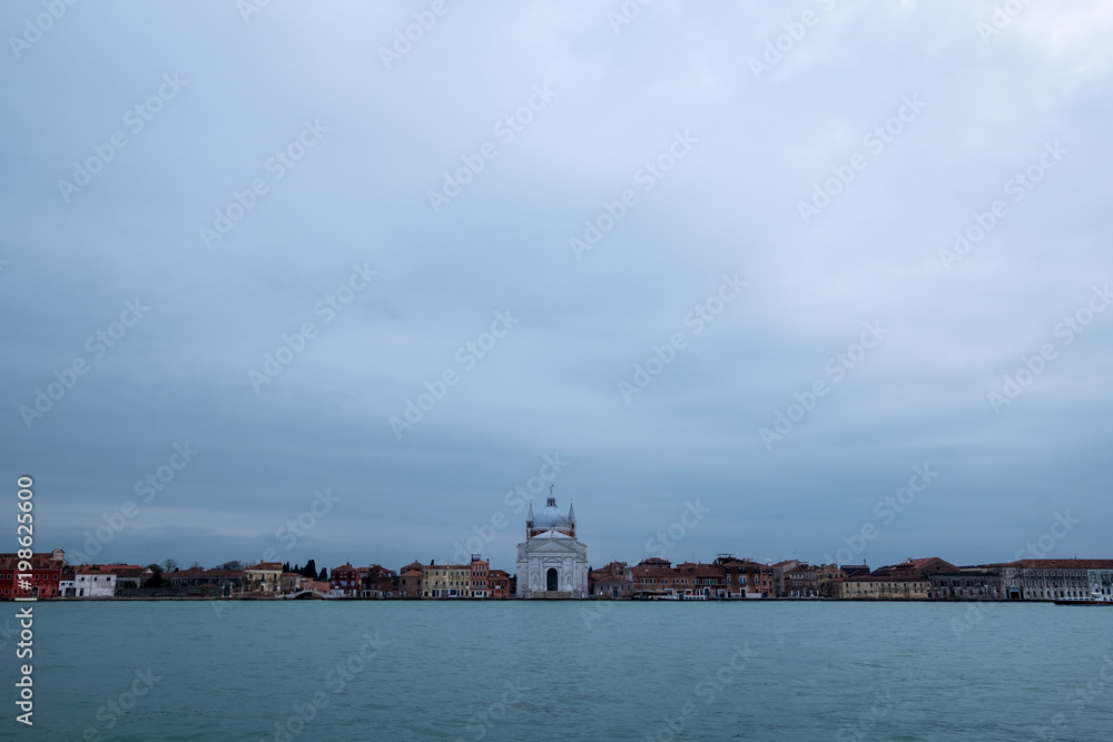 Panoramic view of La Giudecca taken from the lagoon at dusk on a cloudy winter's day, showing Church of Santissimo Redentore in the centre of the photo.