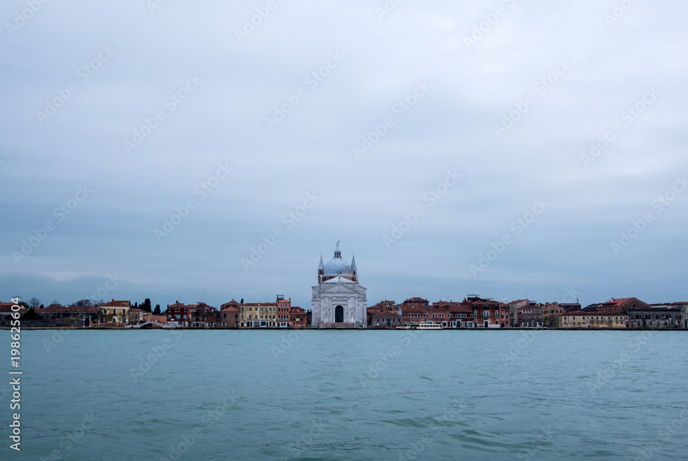 Panoramic view of La Giudecca taken from the lagoon at dusk on a cloudy winter's day, showing Church of Santissimo Redentore in the centre of the photo.