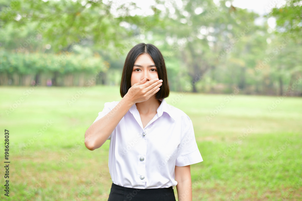 Education Concepts. Beautiful young Asian girl is thinking seriously. Beautiful Asian students are thinking in the garden. Beautiful young student is headache in the garden. Education Concepts. Beautiful young Asian girl is thinking seriously. Beautiful Asian students are thinking in the garden. Beautiful young student is headache in the garden.