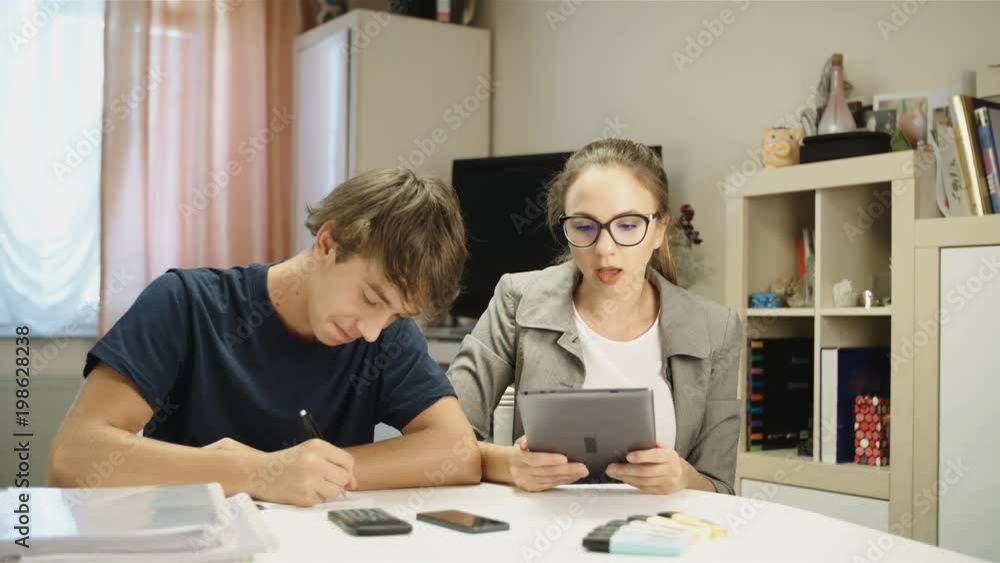 Woman help schoolboy with homework and starts laughing 4K Woman help schoolboy with homework and starts laughing 4K