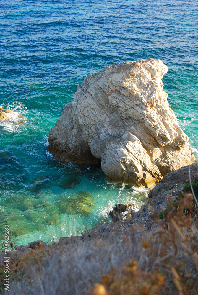 Big rock that emerges from the italian and crystalline sea