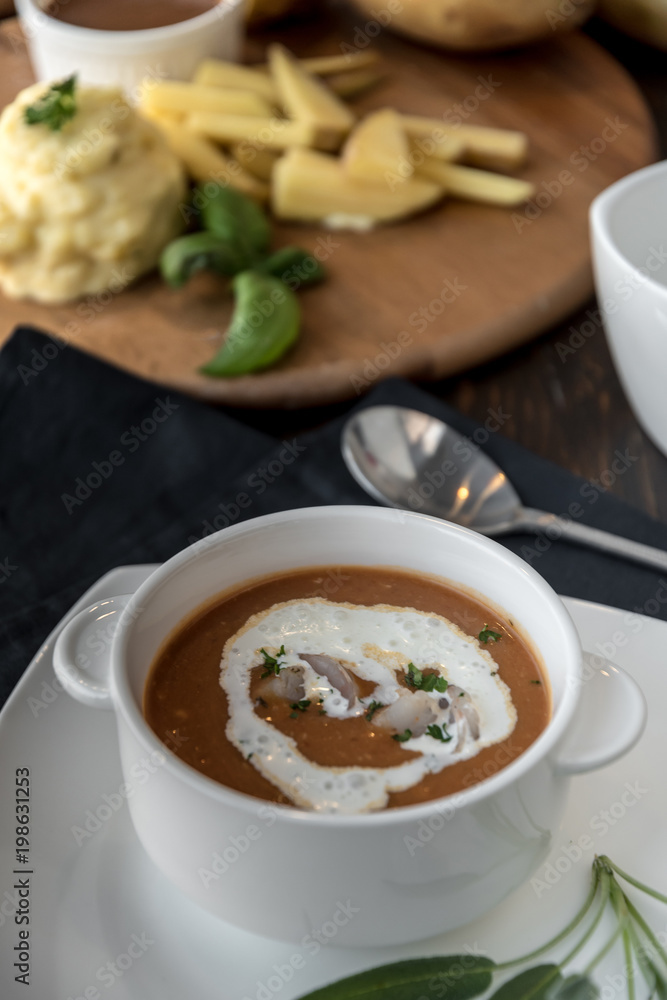 Vegetable cream soup with shrimps in bowl on table Vegetable cream soup with shrimps in bowl on table
