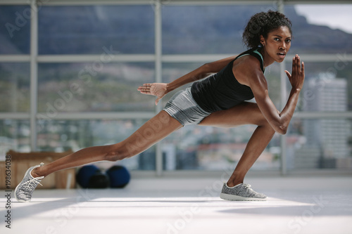 Slim african woman exercising in gym