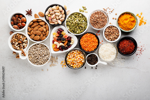 Composition with assortment of superfood products in bowls on gray background, top view
