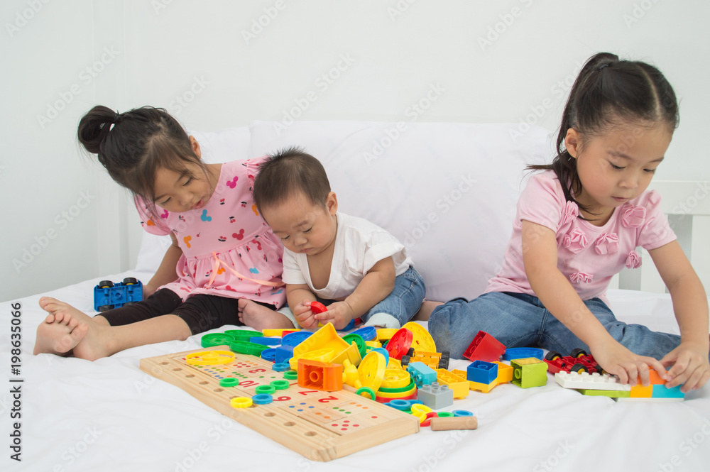 Concepts of learning skills. Little Children are learning skills to play with toys. Little Children are playing in the playroom. Asian Little Children playing with friends in the bedroom Concepts of learning skills. Little Children are learning skills to play with toys. Little Children are playing in the playroom. Asian Little Children playing with friends in the bedroom