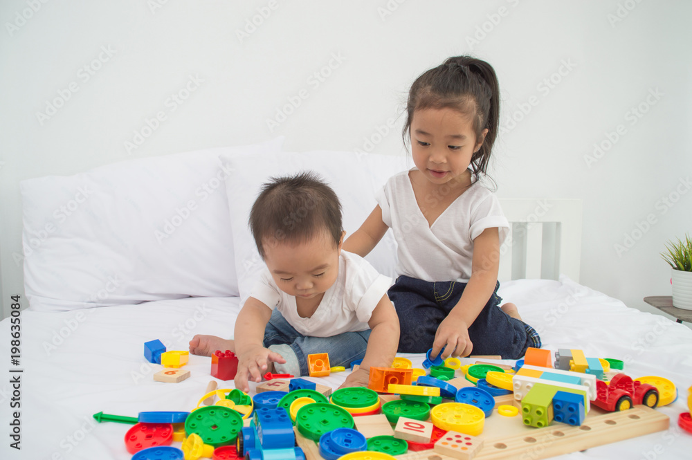 Concepts of learning skills. Little Children are learning skills to play with toys. Little Children are playing in the playroom. Asian Little Children playing with friends in the bedroom Concepts of learning skills. Little Children are learning skills to play with toys. Little Children are playing in the playroom. Asian Little Children playing with friends in the bedroom