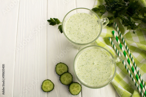 Yogurt smoothie  with  cucumber on the white wooden background.Top view.
