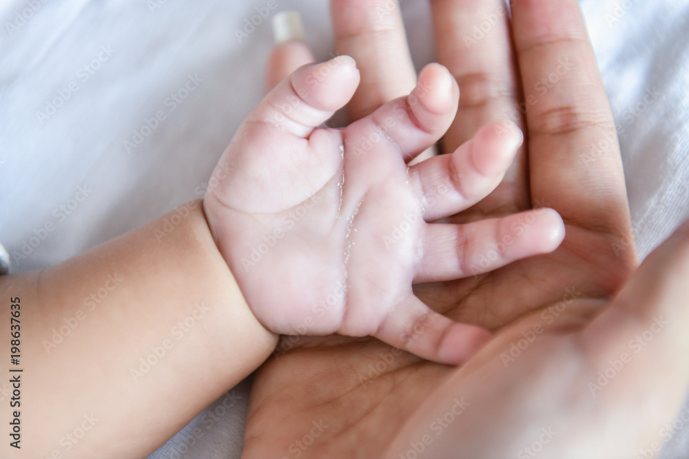Newborn Concept. Mother and child on a white bed. Mom and baby boy playing in bedroom. Parent and little kid relaxing at home. Family having fun together. Newborn baby is fussing and crying. Newborn Concept. Mother and child on a white bed. Mom and baby boy playing in bedroom. Parent and little kid relaxing at home. Family having fun together. Newborn baby is fussing and crying.