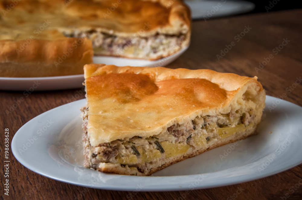 Triangular piece of pie is taken out of pie on a separate white plate Triangular piece of pie is taken out of pie on a separate white plate