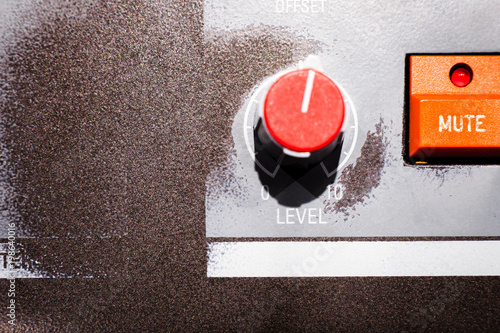 Картината върху платно Close-up shot of level knob with numbered label with mute button on worn metal board with faded whte detail