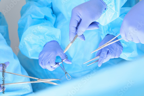 Close-up of unknown surgeons at work while operating at hospital. Health care and veterinary concept