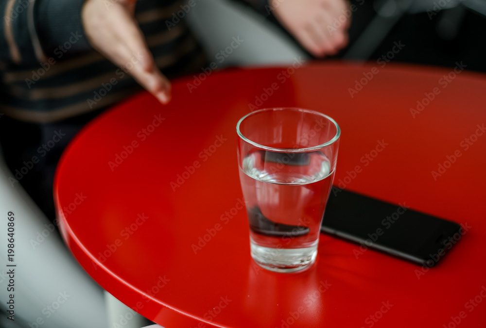 Glass of water on a red table Glass of water on a red table