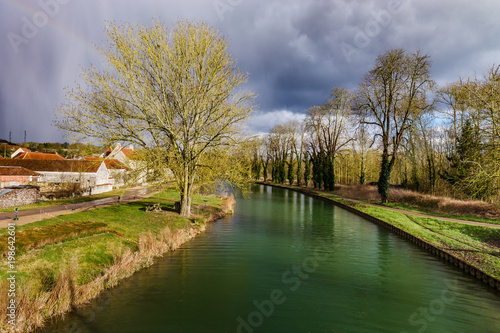 Green water of canal and blue sky, springtime in countryside © 31etc