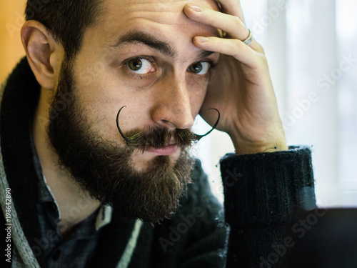 Modern, Expressive Bearded Office Clerk with Mustages Working with Notebook at Office photo