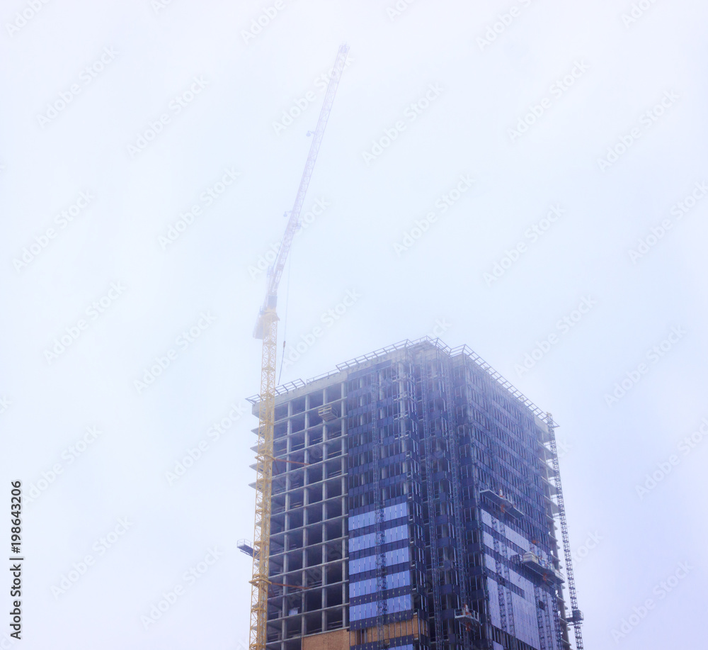 building, skyscraper. It is made of concrete and glass. Crane in the open