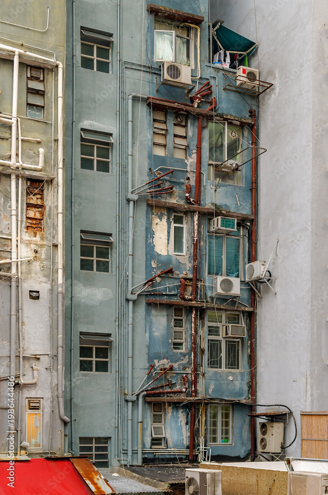 Heruntergekommenes Hochhaus mit rostigen Rohrleitungen in den Hongkonger Mid-Levels