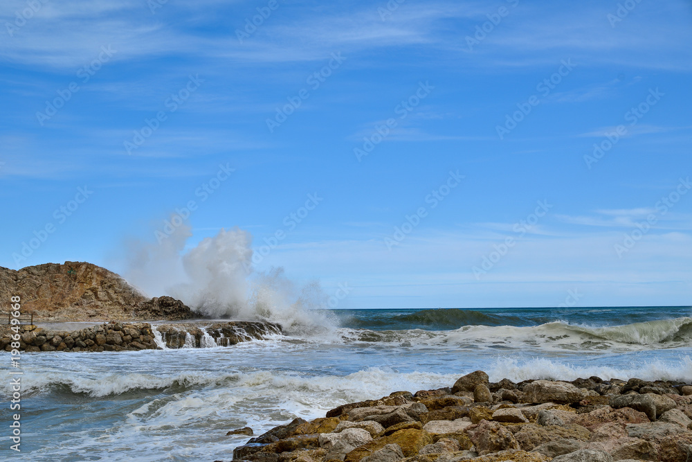 Cullera, Valencia, Spain: 03.25.2018; The splash of waves  in the rock coast