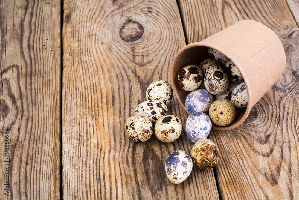 Quail eggs in cardboard box on wooden table Quail eggs in cardboard box on wooden table