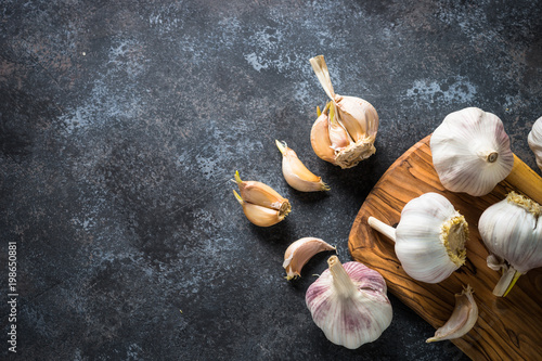 Garlic cloves on a dark stone background. 