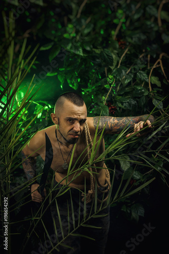 a man in the jungle with machetes attacking the enemy