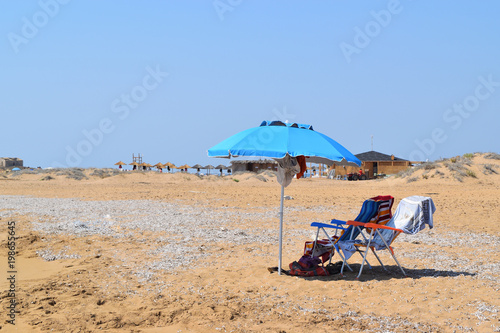 isolated beach umbrella and deck chairs on the beach in summer