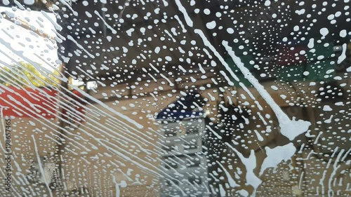close up of front mirror surface of car cover with car wash soap in the car cleaning center.